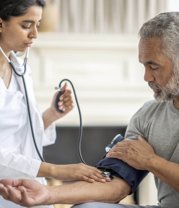 A lady doctor measuring blood pressure of a old man