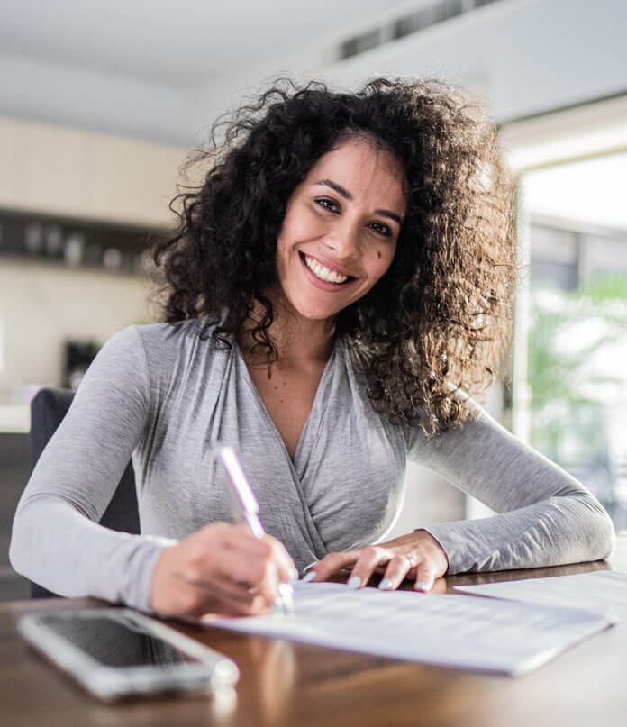 A lady writing on paper with Smile